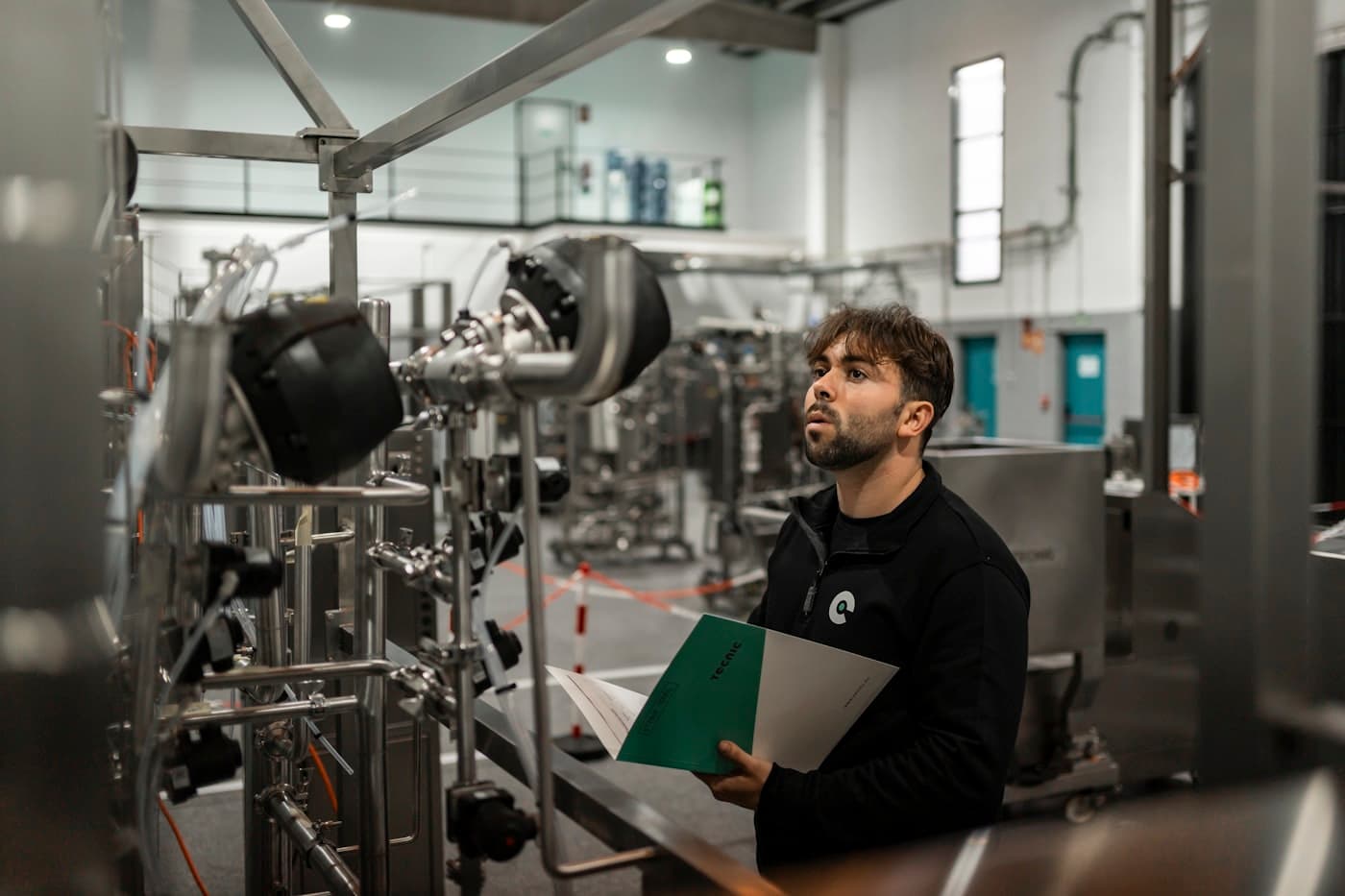 Engineer reviewing service records while inspecting plant equipment