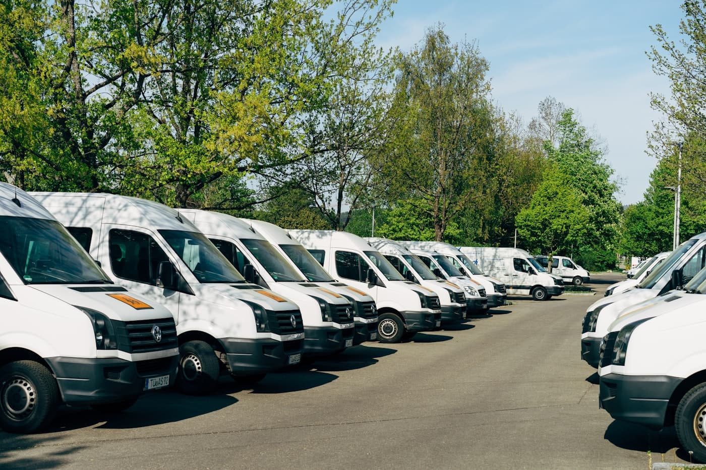 Row of white work vans in a depot