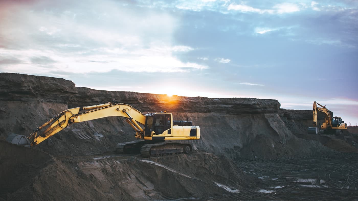Excavators working on an earthmoving site at sunrise