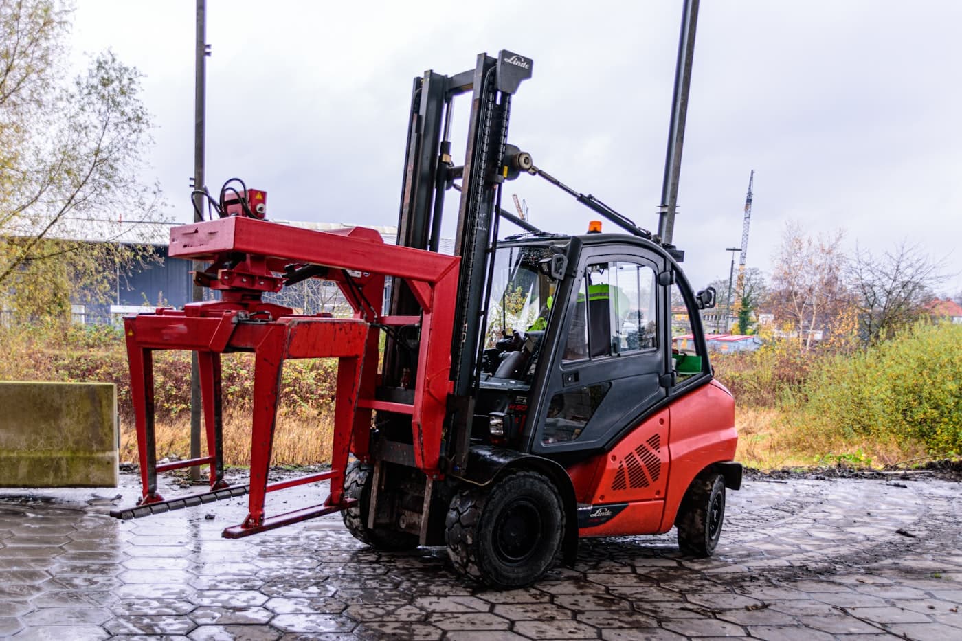 Counterbalance forklift with attachment parked in a yard
